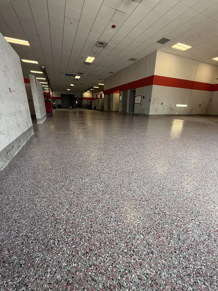 Grey decorative flake floor running down a long dealership hallway